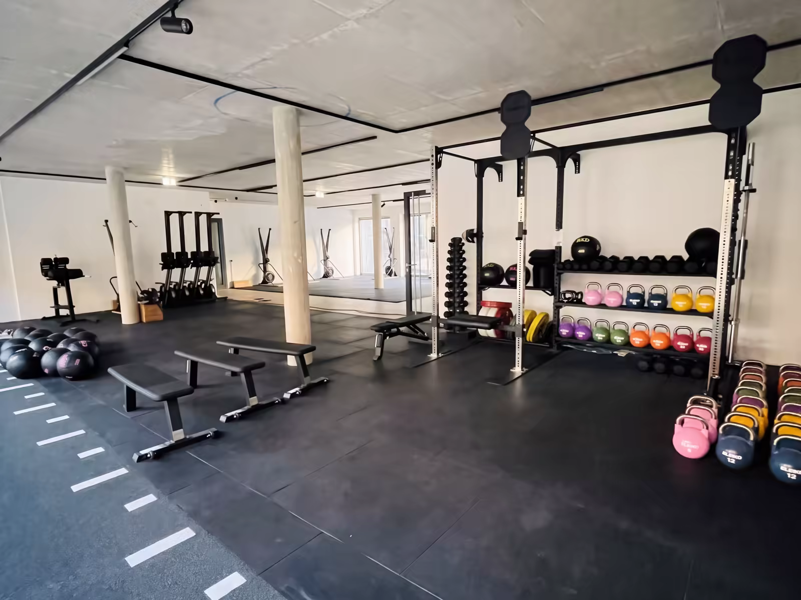 Trainingsfläche bei Forvya mit Rack, Bänken und Kettlebells