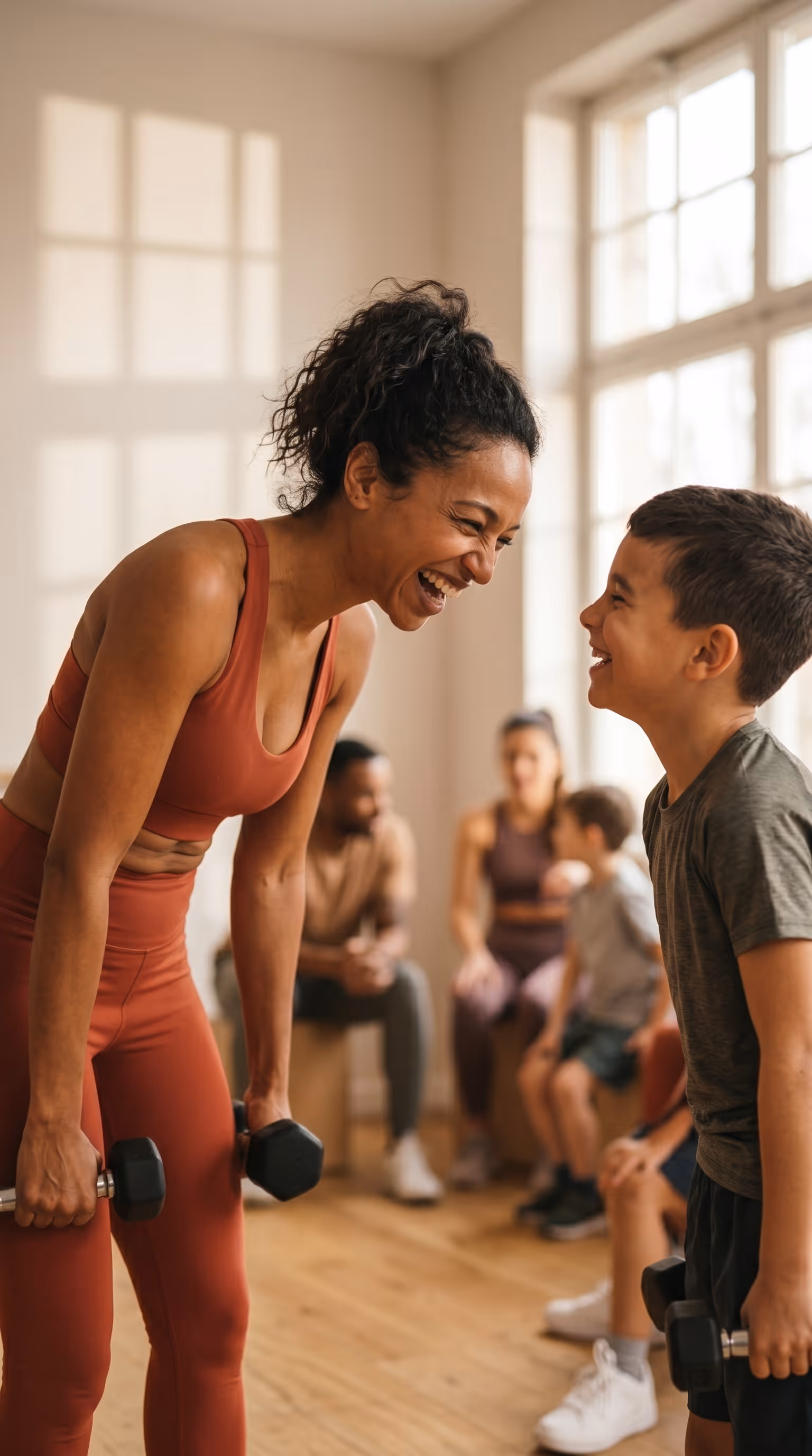 Eine Frau und ein Junge lachen zusammen, im Hintergrund weitere Kinder.