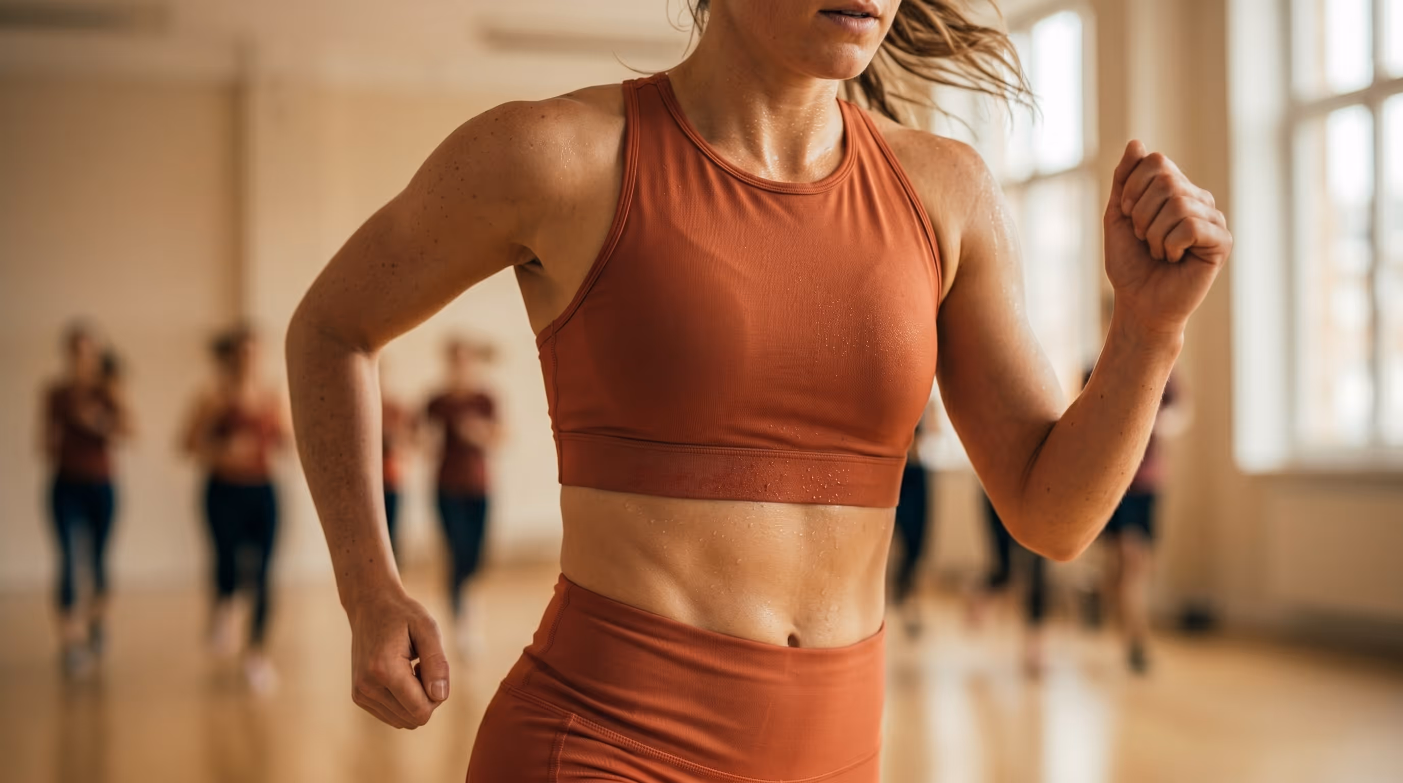 Eine Frau läuft im Training, im Hintergrund weitere Läufer.